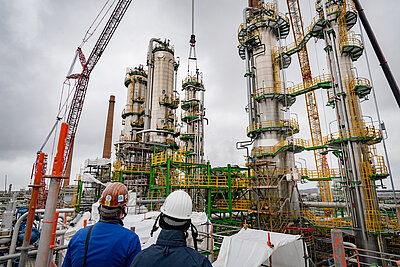 Zwei Ingenieure blicken auf eine Rohöl-Anlage